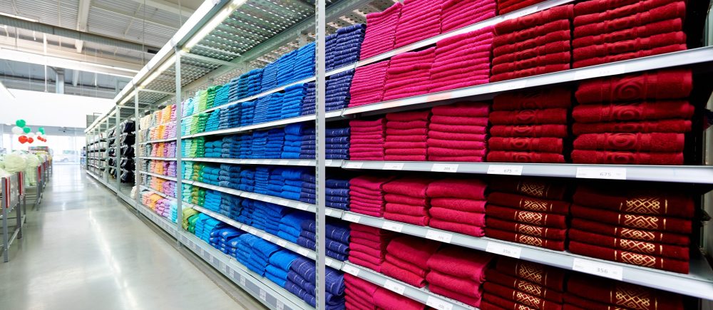 Rows of shelves with terry towels in a supermarket.